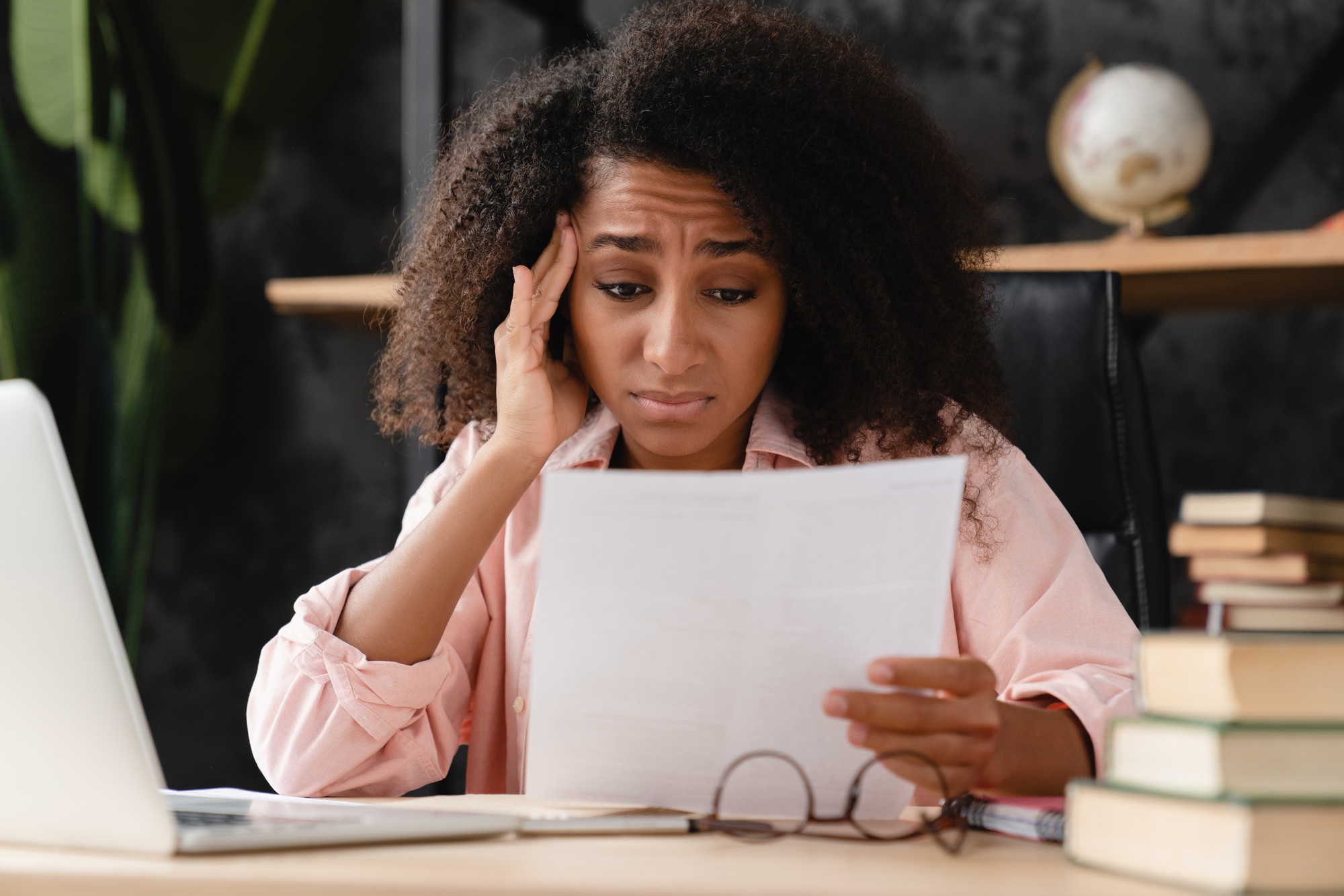 Sad exhausted depressed woman reading document with debt loan mortgage domestic bills.Sad bad news